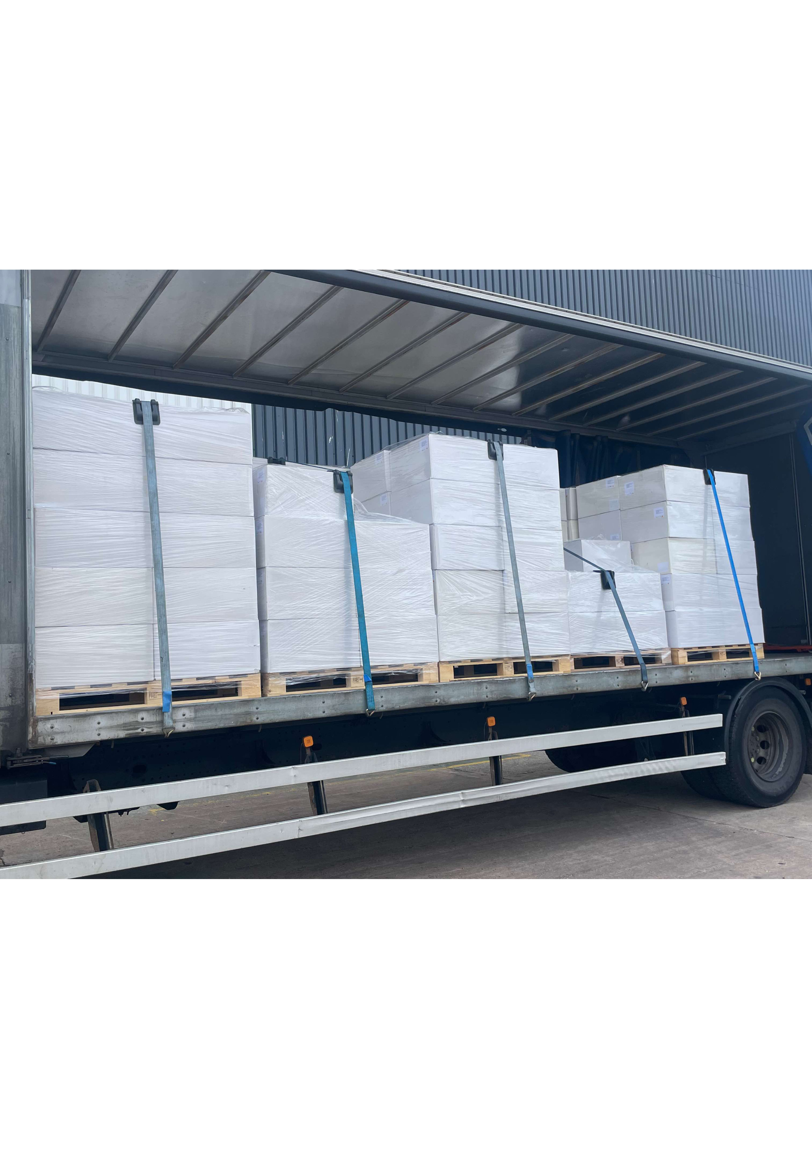 Curtain side lorry with side partially open revealing shrink wrapped palletised goods secured with blue straps during a regional retail delivery