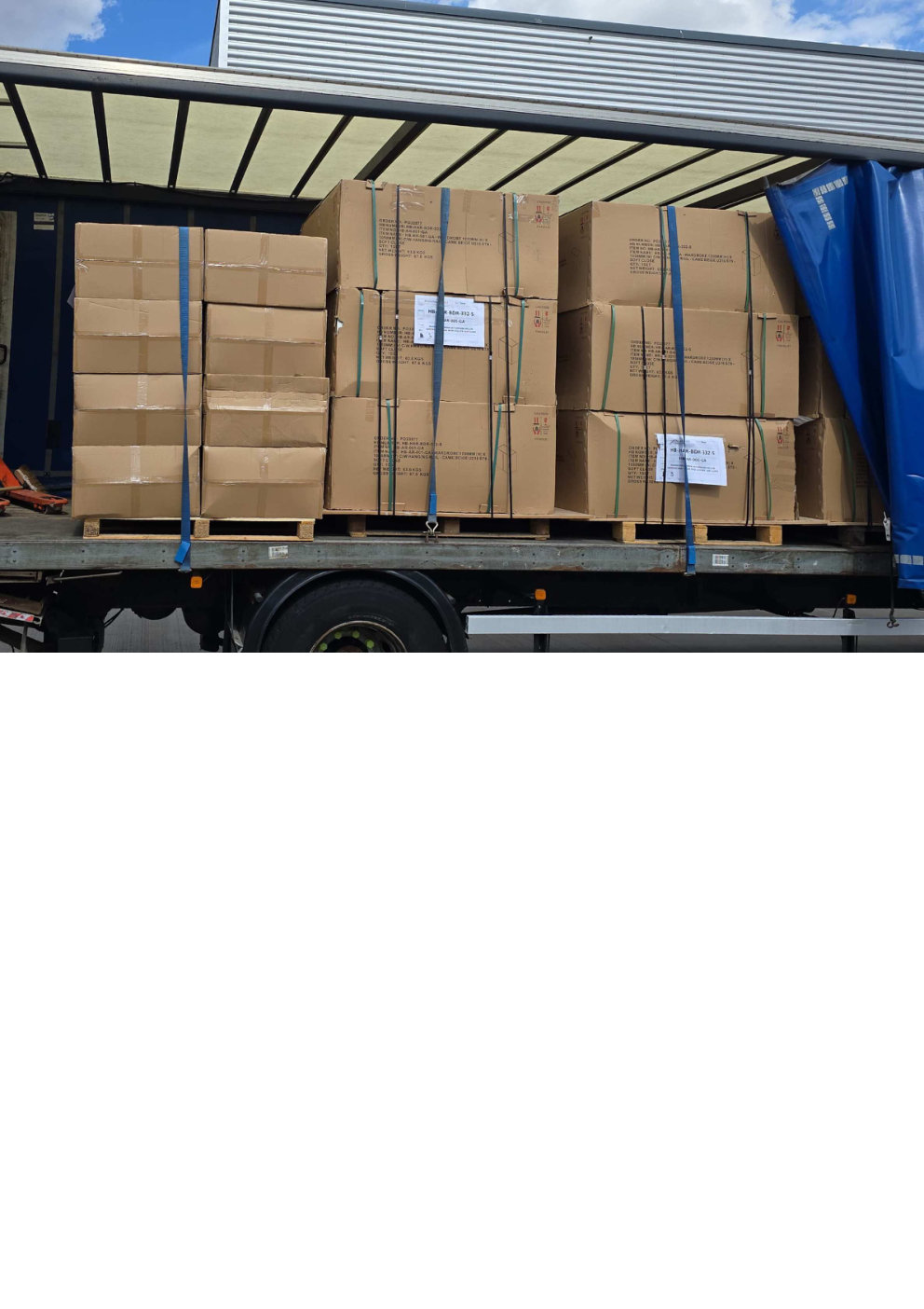 Pallets of flat packed wardrobe cartons strapped securely inside a curtain sided lorry ready for fragile freight delivery across the region
