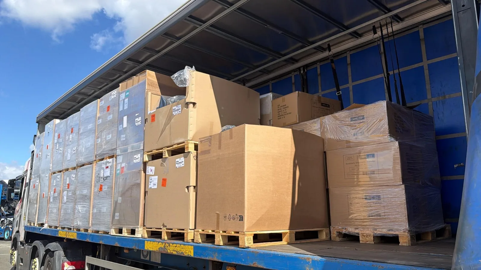 Palletised ADR consignment of shrink wrapped and boxed automotive goods secured on a curtain side trailer for delivery to Tilbury Docks