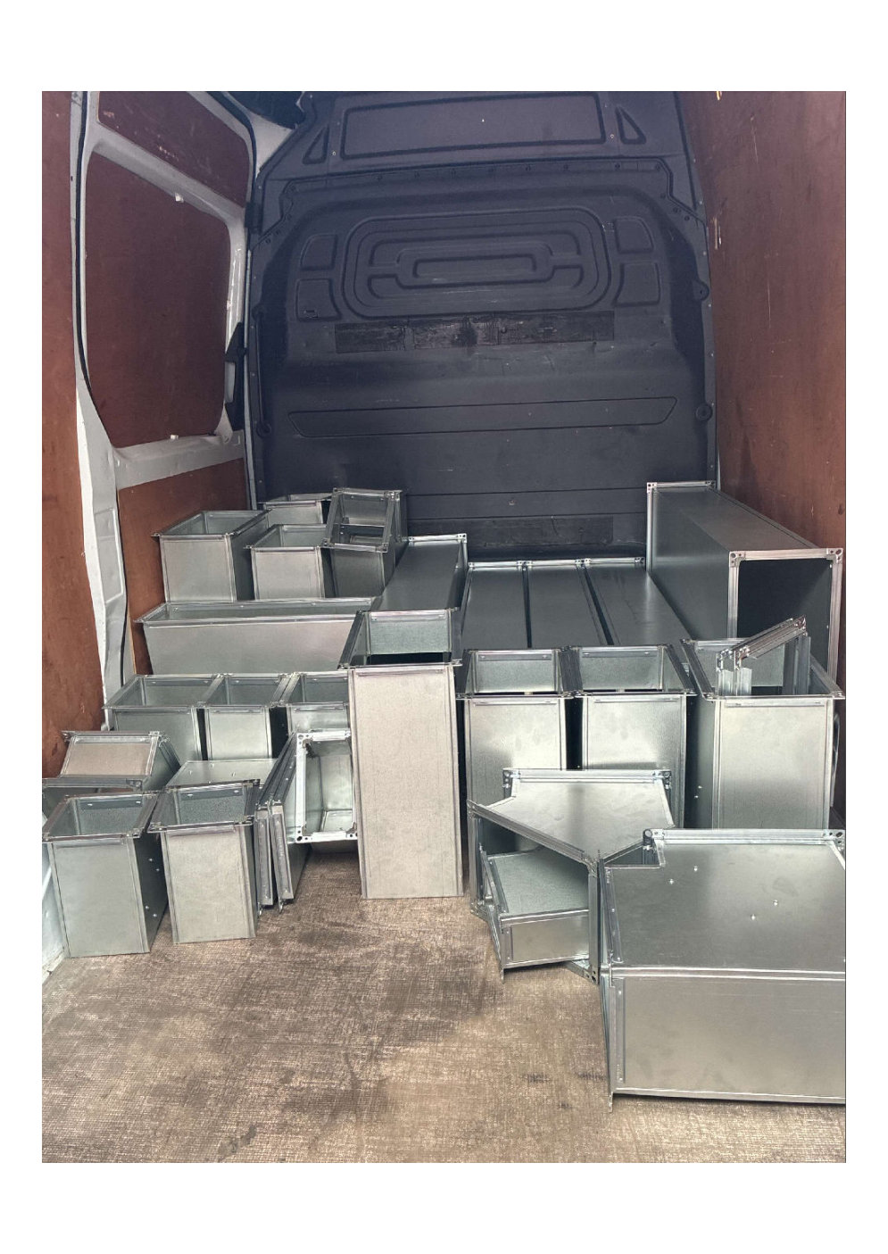 galvanized steel HVAC ducting sections stacked in the back of a cargo van ready for delivery