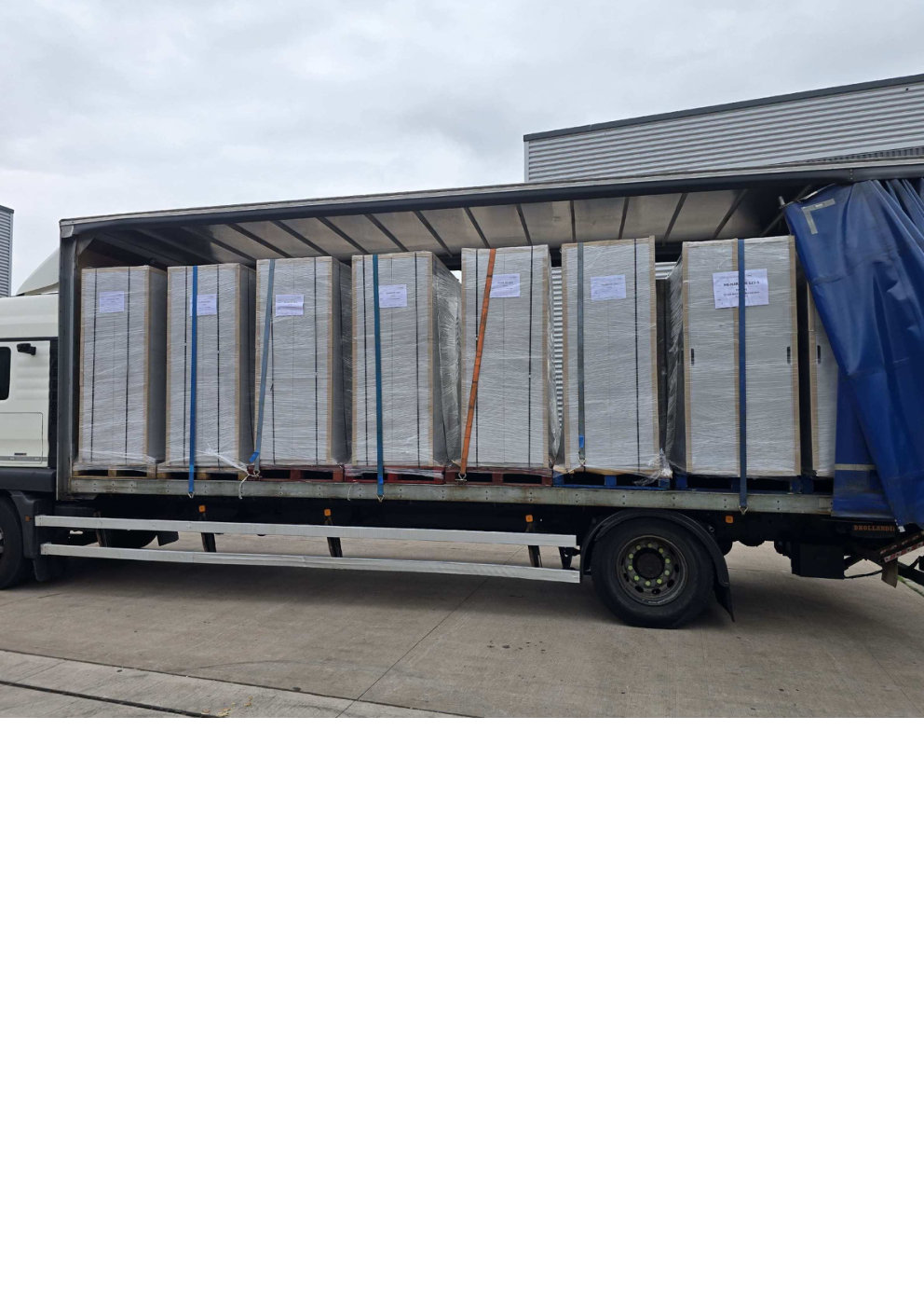 Curtain-side artic trailer loaded with strapped shrink-wrapped pallets